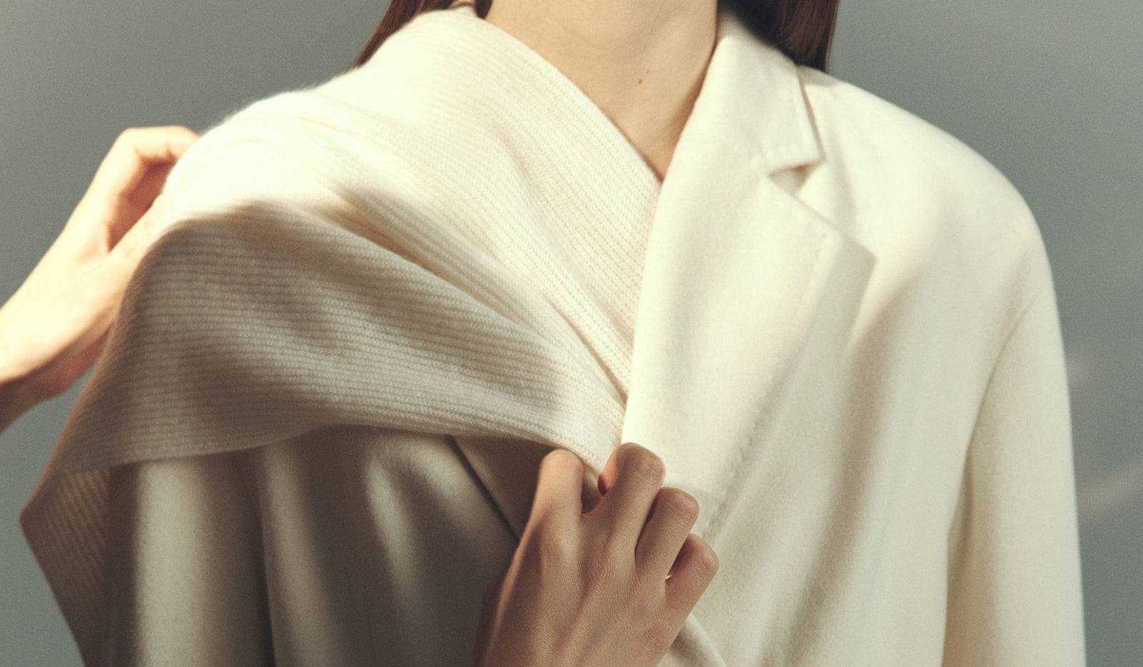 Person wearing a white kimono-style garment against a gray background