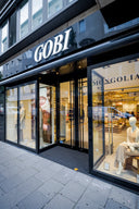 GOBI Cashmere store in Düsseldorf: storefront with lit sign, window displays and mannequins in knitwear