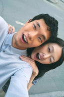 Smiling couple outdoors, man in light blue cashmere polo showing men's Valentine's Day outfits, close-up view