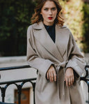 Model in beige belted coat with wide lapels outdoors, showing cashmere fall essentials styling, front view