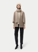 front view of a beige beanie, scarf, a beige poncho and black pants #color_beige