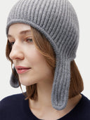 Woman wearing a gray knit hat with ear flaps on a light gray background #color_dim-gray