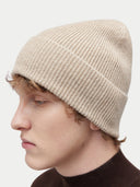 side view of a man wearing a beige beanie