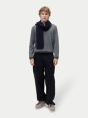 Man wearing a gray sweater, black scarf, black pants, and brown shoes on a white background #color_navy-blazer