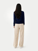 back view of a Person wearing a navy sweater and beige pants on a white background #color_navy