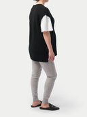 Person wearing a black sweater with white sleeves, gray leggings, and black sandals on a white background #color_dawn-blue