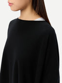 side-view of a black poncho worn by a person on a white background #color_black