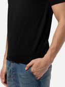 Person wearing a black t-shirt and blue jeans on a white background