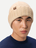 Person wearing a beige knit beanie with a logo on a white background #color_beige