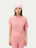 Person wearing a pink ribbed knit outfit on a white background.