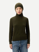 front view of a person wearing a green turtleneck sweater and beanie with blue jeans on a white background #color_avocado