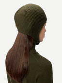 side view of a person wearing a green knit beanie and sweater on a white background #color_avocado