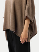 Brown poncho worn by a person on a white background