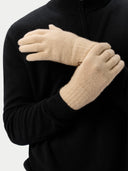 Person wearing beige gloves with a black background#color_beige