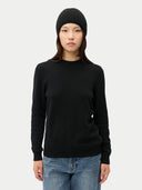 Person wearing a black sweater and black beanie on a white background #color_all