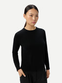 Woman wearing a black long-sleeve top against a white background #color_black