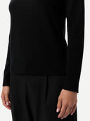 Close up of a black long-sleeve top worn by a person on a white background #color_black