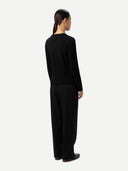 Back view of a person wearing a black outfit on a white background #color_black