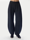 A person wearing dark navy wide-leg knit pants and black loafers, shown from the waist down against a plain light gray studio background.