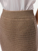 Close-up of a brown knitted skirt with a white blouse underneath. #color_taupe