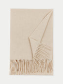 flat lay of a beige fringed scarf on a light gray background