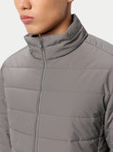 close up of a gray puffer jacket worn by a person on a light gray background #color_dim-gray