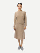 Woman wearing a beige sweater and skirt set on a white background #color_warm-grey