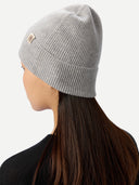 side view of a person wearing a gray knit beanie with a brand logo on a white background #color_high-rise 
