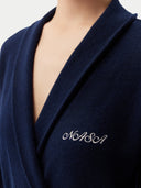 A close-up of a navy blue wrap-style garment with the word "NASA" embroidered in white cursive on the chest.  #color_taupe