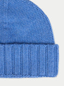 close up of a blue knit beanie on a light gray background #color_blue