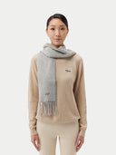 woman wearing a beige sweater with a gray scarf and beige pants #color_default