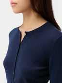 Navy blue crew neck cardigan worn by a person on a white background #color_mood-indigo