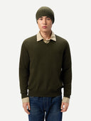 Man wearing a green sweater, beige shirt, and blue jeans on a white background #color_avocado