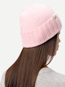 back view of a person wearing a pink knit beanie on a white background #color_almond-blossom