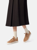 close up of a black skirt and almond color cashmere sneakers with white socks #color_toasted-almond