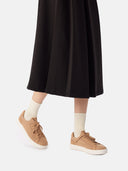 side view of a black skirt and almond color sneakers with white socks  #color_toasted-almond