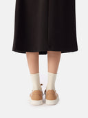 back view of a black skirt and almond color sneakers with white socks  #color_toasted-almond