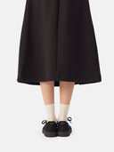 back view of a black skirt and black knitted cashmere sneaker with white socks #color_black