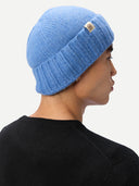 back view of a man wearing a blue knit beanie with a brand logo on a white background #color_blue