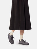 side view of a black skirt and gray knitted sneakers with white socks  #color_frost-gray