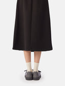 back view of a black skirt and gray knitted sneakers with brand name "GOBI" embossed in the center with white socks  #color_frost-gray