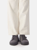 side view of white pants and gray knitted sneakers with white socks #color_frost-gray