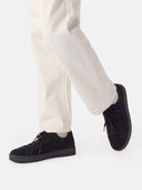 side view of white pants and a black knitted sneakers #color_black