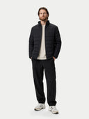 front view of man wearing a black puffer jacket and black pants on a white background #color_black