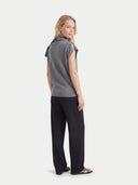 back view of a woman wearing a gray sleeveless top and black pants on a white background #color_steel-gray
