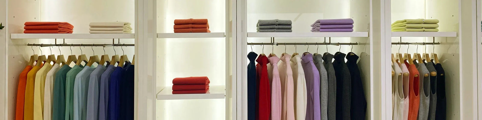 Closet with clothes on hangers and folded at the top