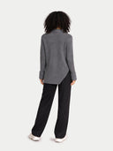 Person wearing a gray sweater and black pants on a white background #color_steel-gray