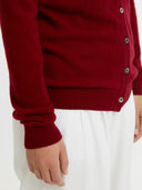 close up of a dark red cardigan and white pants on a white background #color_bordeaux