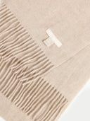 close up of a warm gray fringed scarf with a small label "GOBI ORGANIC" #color_warm-grey