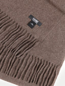 close up front view of a brown fringed scarf with a small label "GOBI"